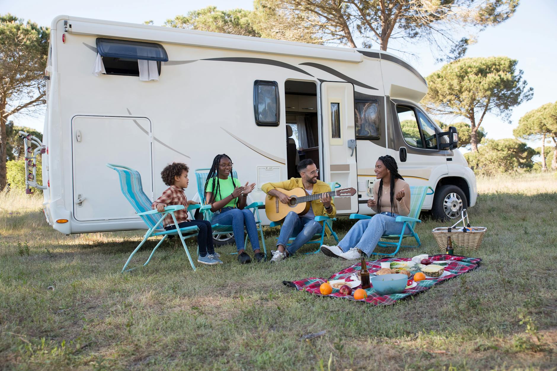 family sitting on blue and white camping chairs